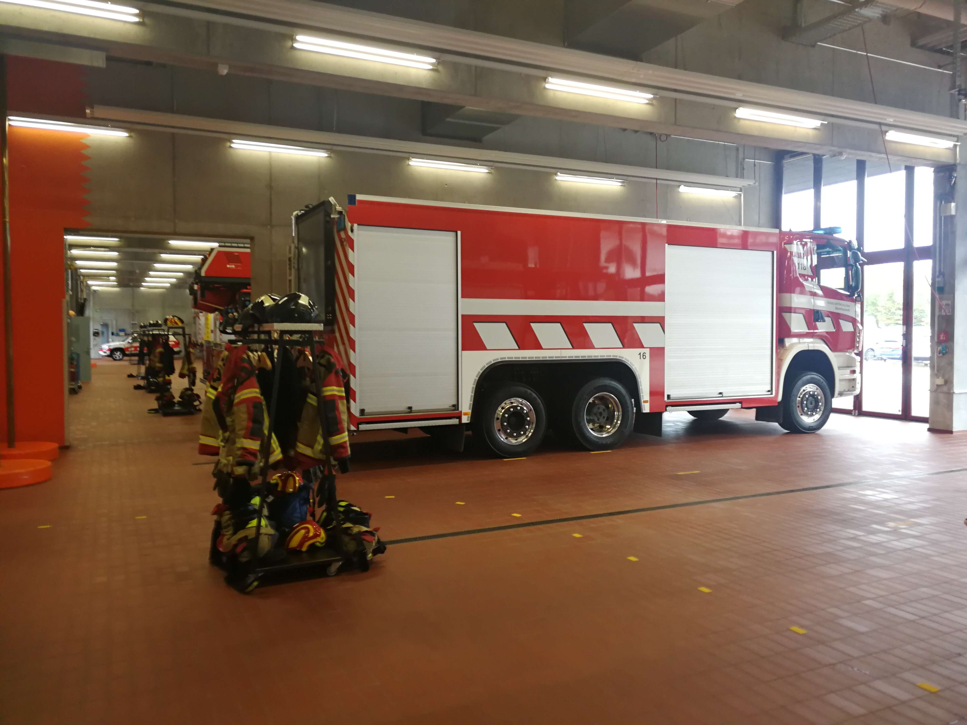 Blick in die lange Fahrzeughalle mit dem Grosslöschfahrzeug mit dem 10'000 Liter Tank im Vordergrund. (aufgenommen von Fabrice Bouquet)